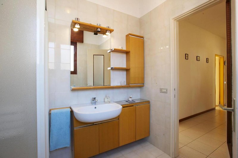 Freundliches Badezimmer mit Dusche, kleiner Badewanne, Bidet und Fenster