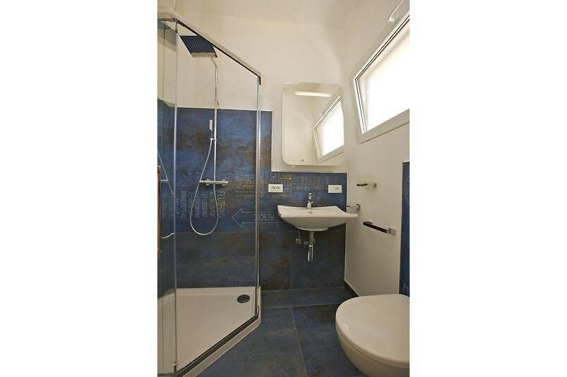 Modernes, freundliches Badezimmer mit Dusche und Fenster
