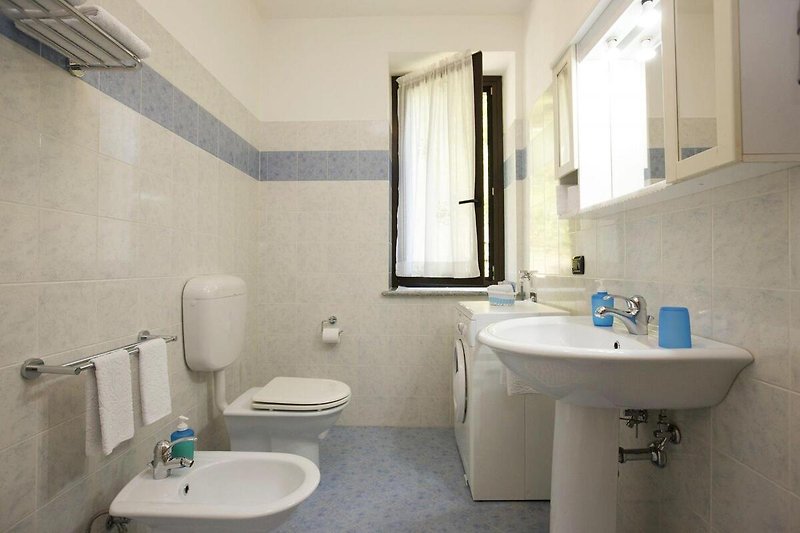 2. freundliches Badezimmer mit Dusche, Bidet, Fenster und Waschmaschine