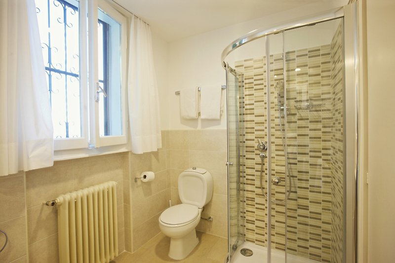 Freundliches, modernes Badezimmer mit Dusche, Bidet und Fenster