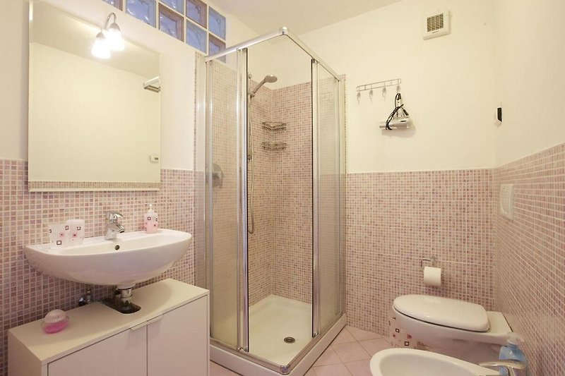 Freundliches modernes Badezimmer mit Dusche, Bidet und Waschmaschine