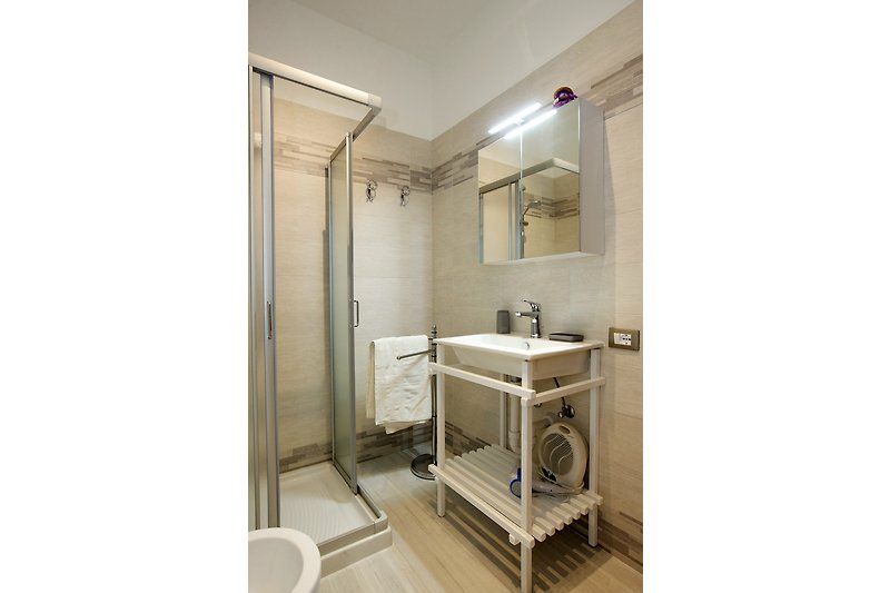 Freundliches und modernes Badezimmer mit Dusche, Bidet und Fenster