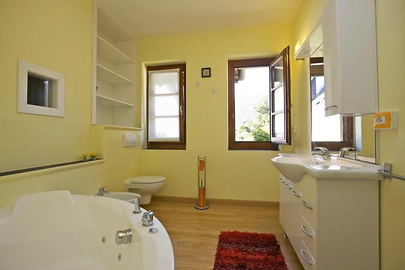 2. freundliches Badezimmer mit Whirlpoolbadewanne, Bidet und zwei Fenstern