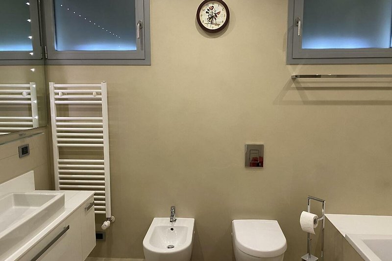 Bad en suite mit großem Waschbecken, Badewannen-/ Duschkombination, WC, Bidet und Fenster
