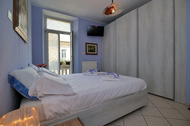 Schlafzimmer mit Doppelbett und Ausgang auf den ca. 2 m² großen Balkon