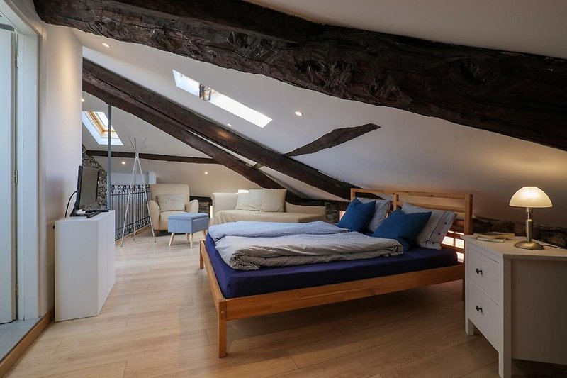 2. Schlafzimmer mit sichtbaren Holzbalken, Doppelbett und ausziehbarer Schlafcouch