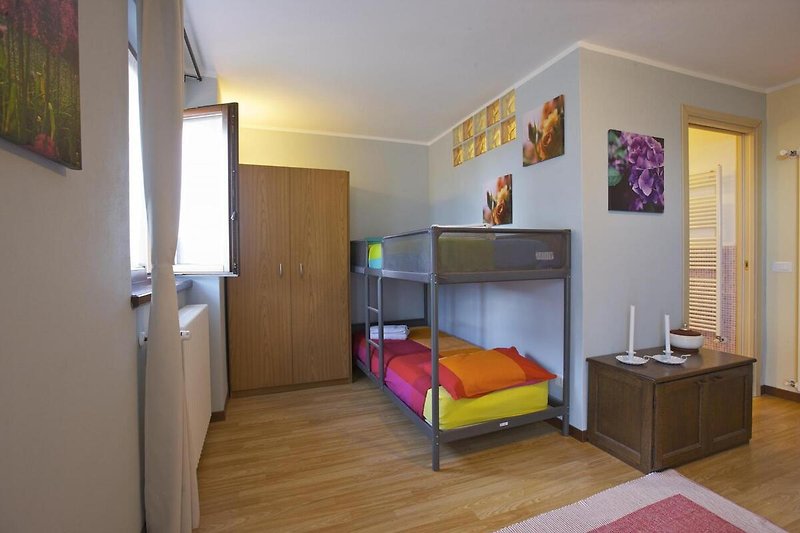 Schlafzimmer mit Doppelbett und Etagenbett für zwei Kinder