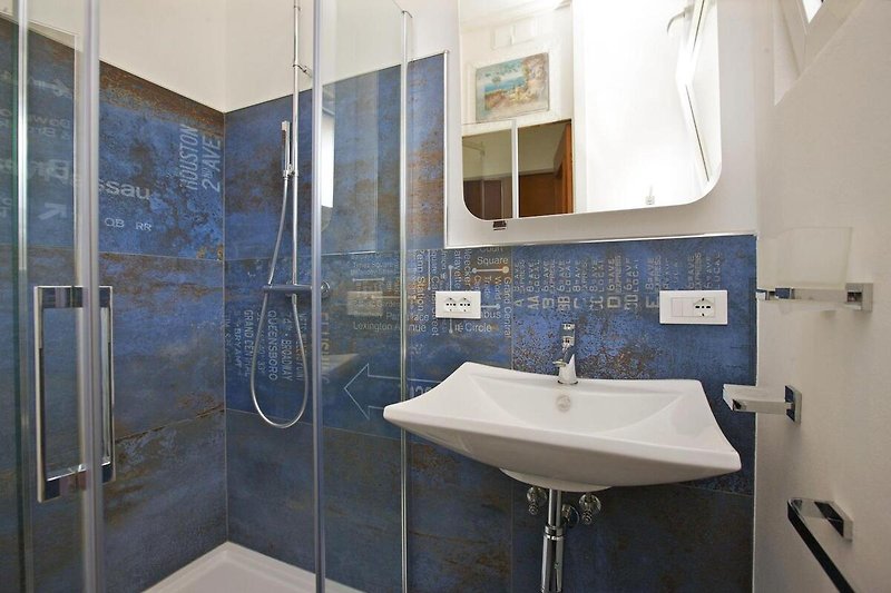 Modernes, freundliches Badezimmer mit Dusche und Fenster