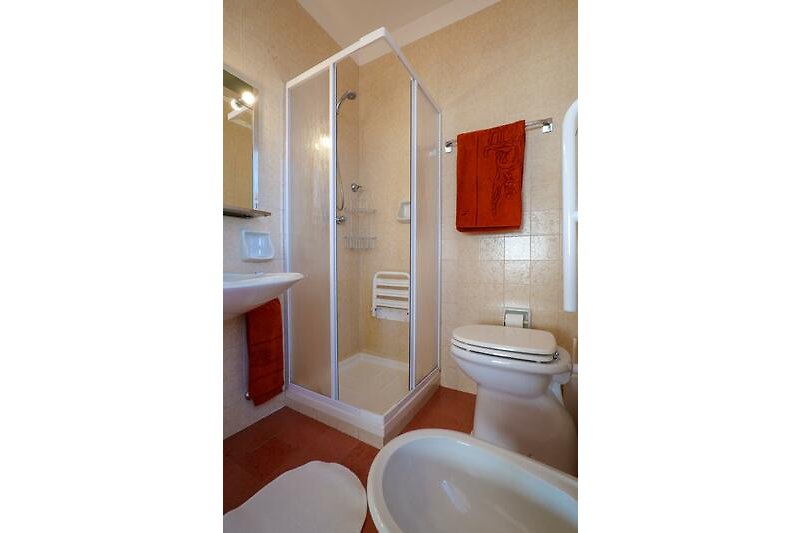 Badezimmer mit Doppelwaschbecken, Dusche, Bidet und Fenster