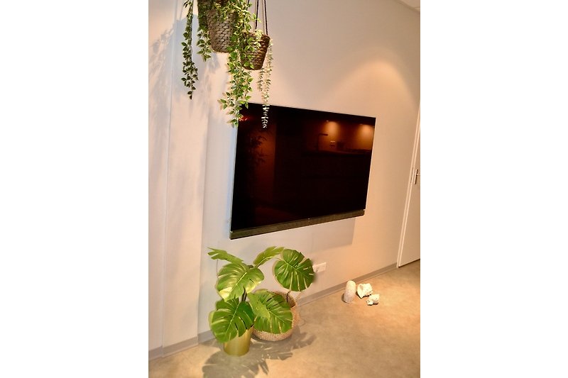 Einladendes Wohnzimmer mit stilvoller Einrichtung und blühenden Pflanzen.