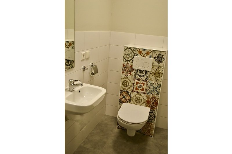Ein stilvolles Badezimmer mit einer weißen Toilette und einem lila Waschbecken.