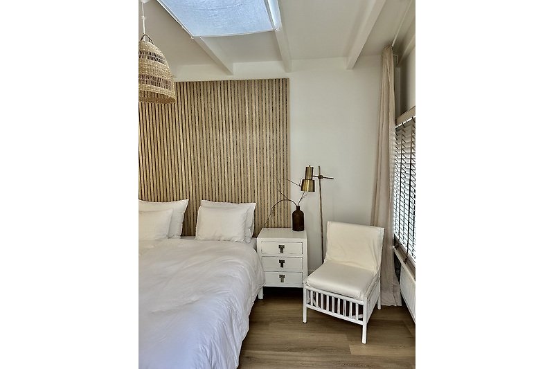 Schlafzimmer mit Holzmöbeln, bequemem Bett und stilvoller Beleuchtung.