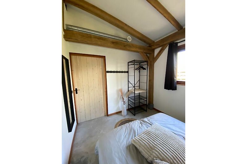 Stilvolles Schlafzimmer mit bequemem Bett und elegantem Holzinterieur.