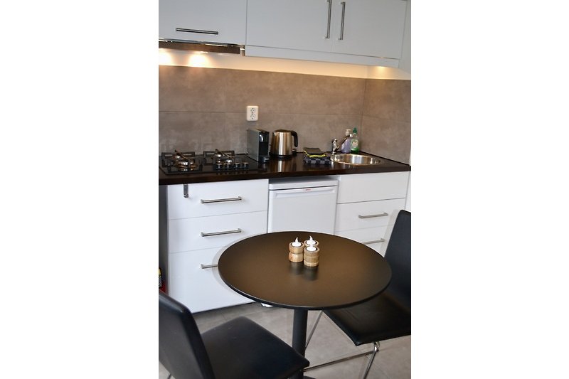 Stilvolle Küche mit braunen Schränken, Holztisch und grauem Stuhl.
