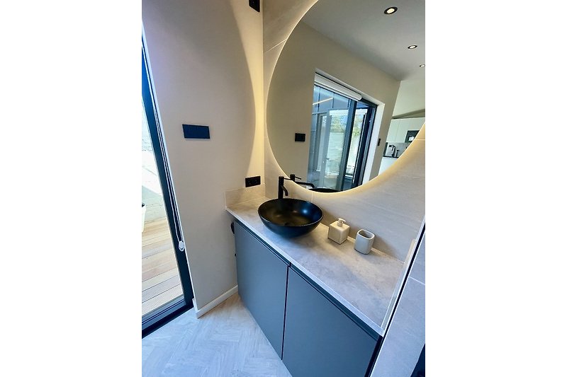 Moderne Badezimmer mit Spiegel, Waschbecken und stilvoller Einrichtung.