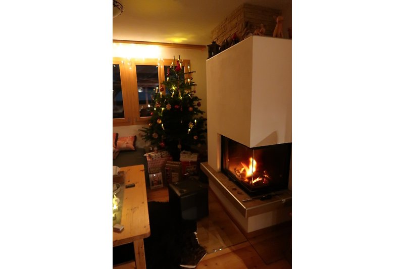 Weihnachtsbaum mit Lichtern und Dekoration in einem gemütlichen Raum.