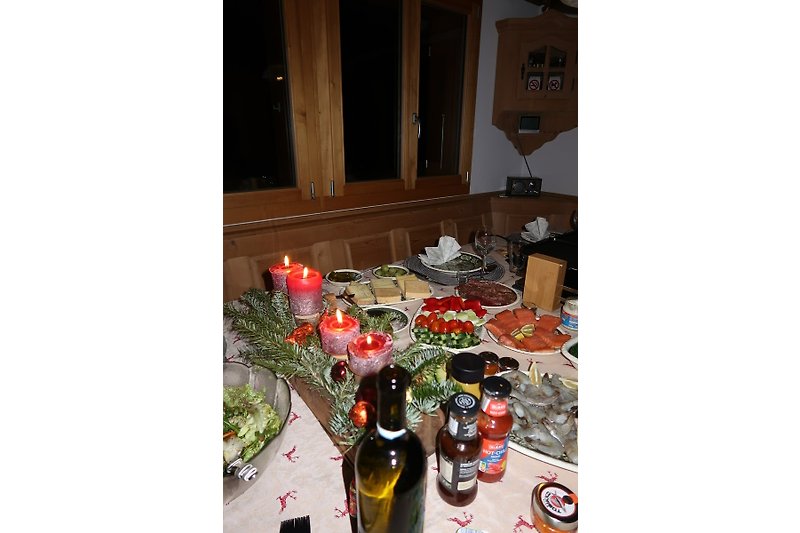 Gemütliche Weihnachtsdekoration mit Flasche und Tischgeschirr in einem traditionellen Raum.