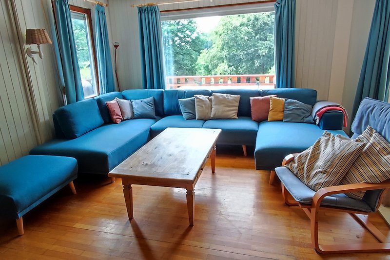 Moderne Wohnung mit blauem Sofa, Holzboden und stilvoller Einrichtung.