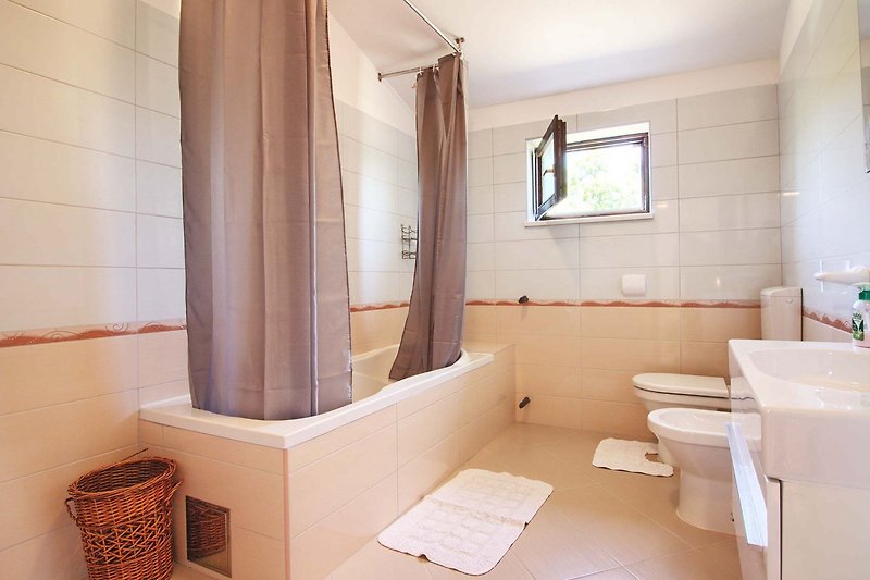 Luxurious bathroom with a ceramic sink, bathtub, and hardwood ceiling.