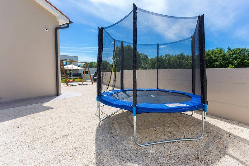 Stylish outdoor play area with modern furniture and lush greenery.
