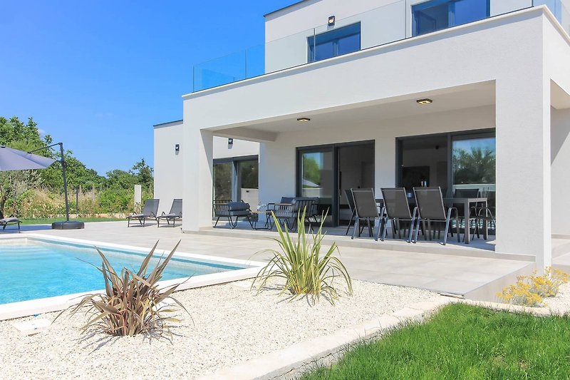 Rent this stylish property with a beautiful swimming pool, outdoor furniture, and a stunning view of the surrounding landscape.