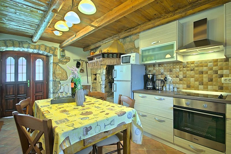 Moderne Küche mit Holzmöbeln und Fensterblick. Gemütlicher Essbereich.