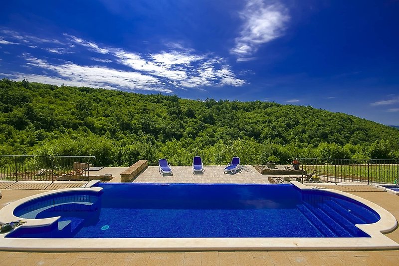 Luxuriöses Resort mit Pool, Sonnenliegen und tropischer Landschaft.
