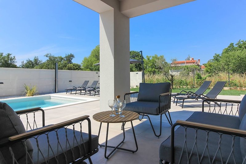 Relax by the poolside with stylish outdoor furniture and a beautiful view.