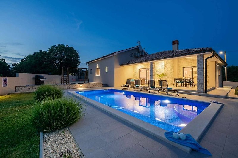 A stunning property with a swimming pool, lush greenery, and beautiful landscaping.