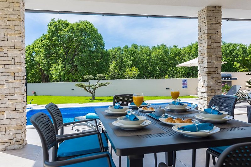 Stylish outdoor furniture under a blue sky with a view of the landscape.