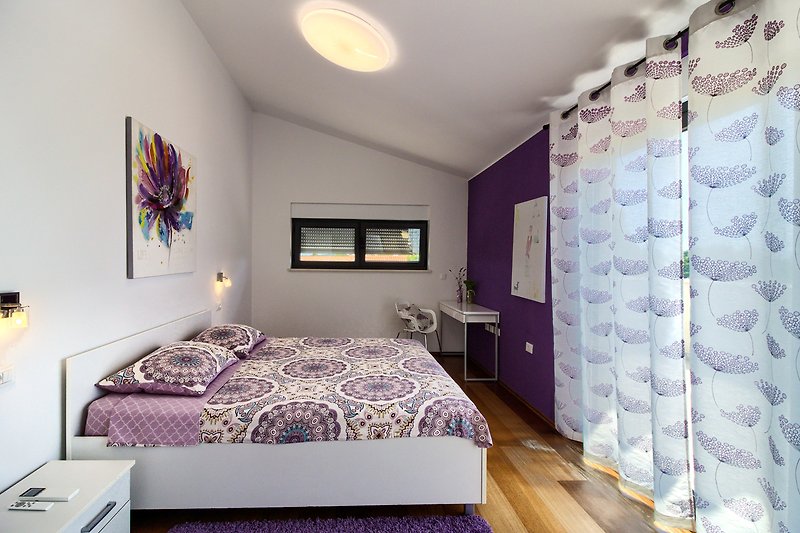 Gemütliches Schlafzimmer mit Holzbett und stilvoller Dekoration.