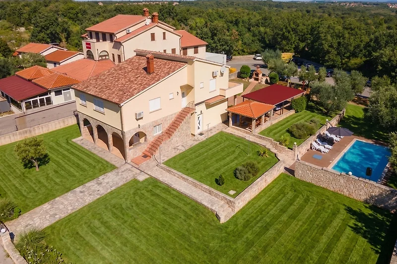 Villa mit Pool und Liegen im Grünen.