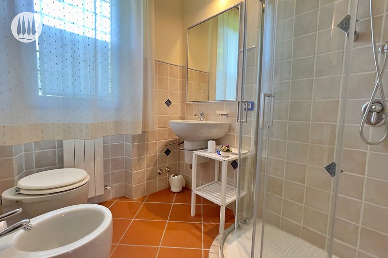 Badezimmer mit lila Akzenten, Spiegel, Fenster und Toilette.