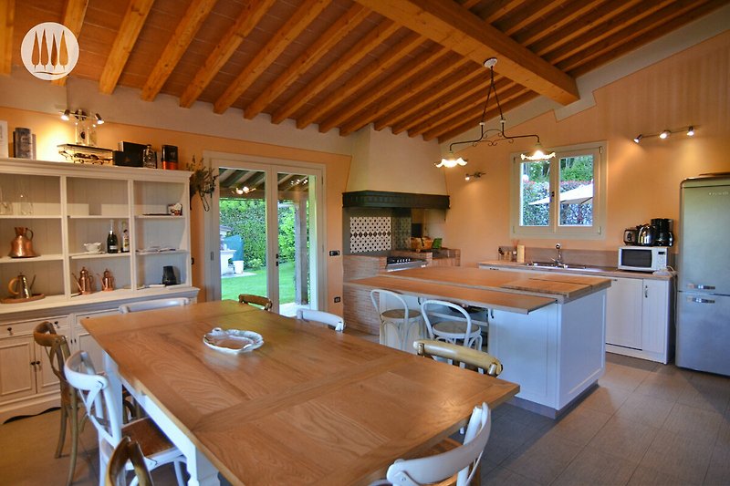 Moderne Küche mit Holzmöbeln, Licht und Küchengeräten.
