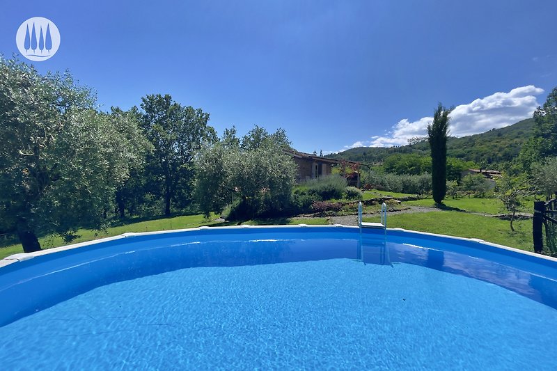 Schönes Haus mit Pool, Garten und blauem Himmel.