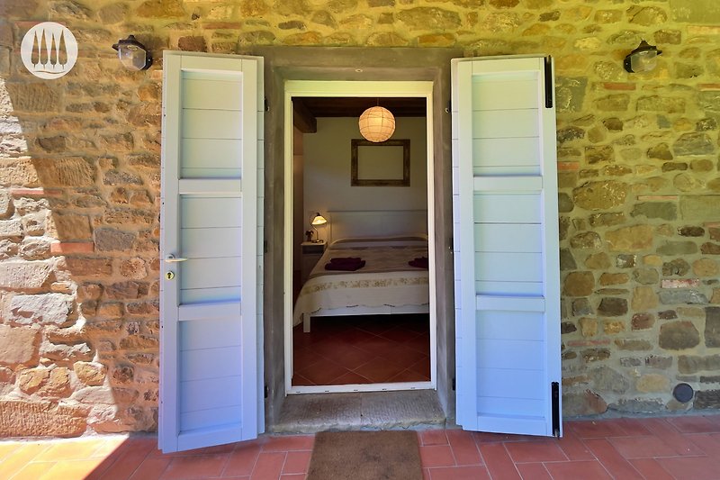 Holzverkleidete Tür mit Griff und Fenster in einem Backsteinhaus.