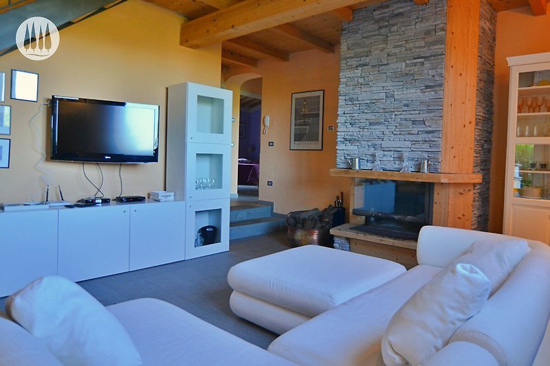 Stilvolles Wohnzimmer mit bequemer Couch, Fernseher und moderner Einrichtung.