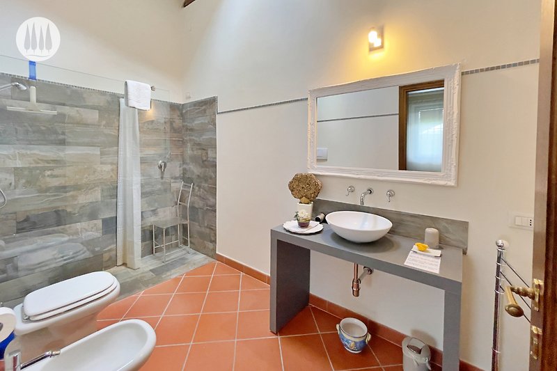 Badezimmer mit stilvoller Einrichtung und Spiegel.