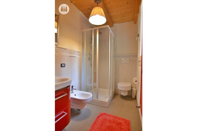 Badezimmer mit lila Akzenten, Dusche, Spiegel und Toilette.
