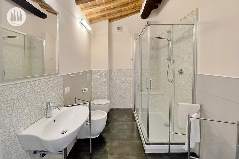 Modernes Badezimmer mit stilvoller Armatur und Glasdusche.