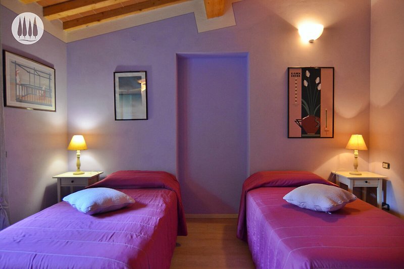 Stilvolles Schlafzimmer mit lila Akzenten und gemütlicher Beleuchtung.