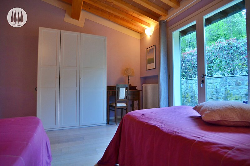 Schlafzimmer mit Holzinterieur, Bett, Lampe und Fenster. Gemütliche Atmosphäre.