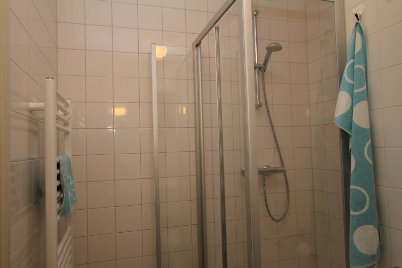 angenehmes Badezimmer mit Fuszbodenheizung, Dusche, Waschbecken und Toilette