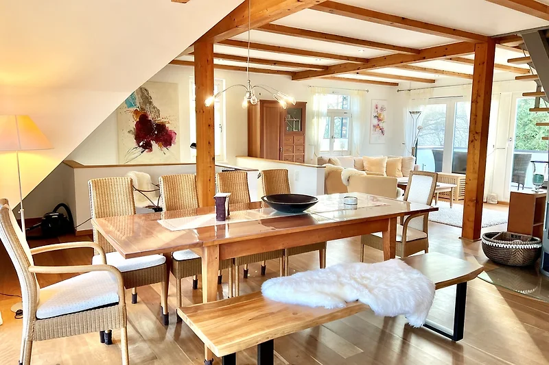 Großzügiger Wohnbereich mit Esstisch, Holzdecke und stilvoller Beleuchtung.