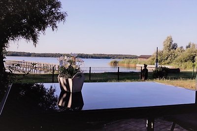 Elegante casa con techo de paja directamente en el lago