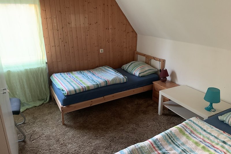 Gemütliches Schlafzimmer mit Holzmöbeln und Bettzeug.
