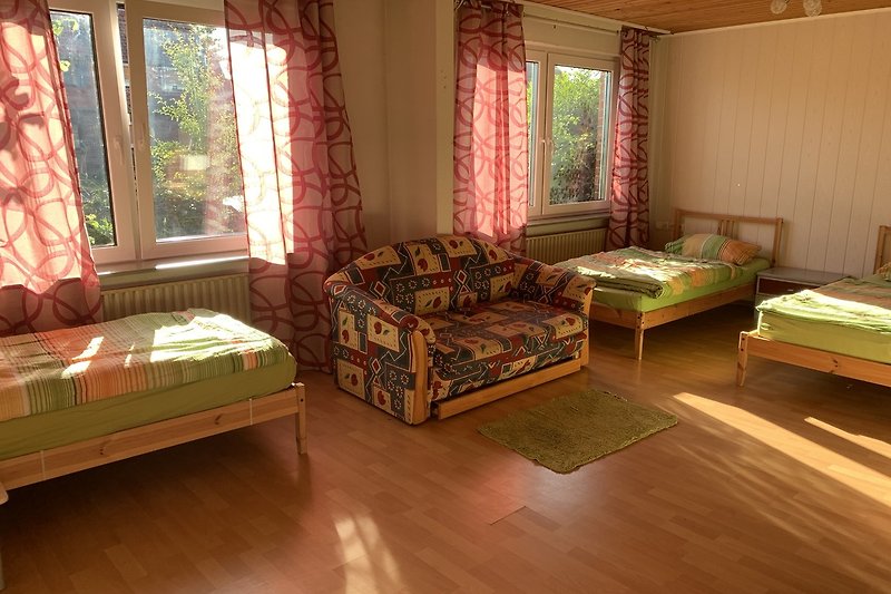 Wohnzimmer mit bequemer Couch, Tisch und Fenster.