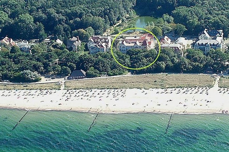 Luftbild vom Dünenschloss (Kreis) direkt am Strand (hinter dem Haus beginnt zudem unmittelbar der weitläufige Stadtwald)