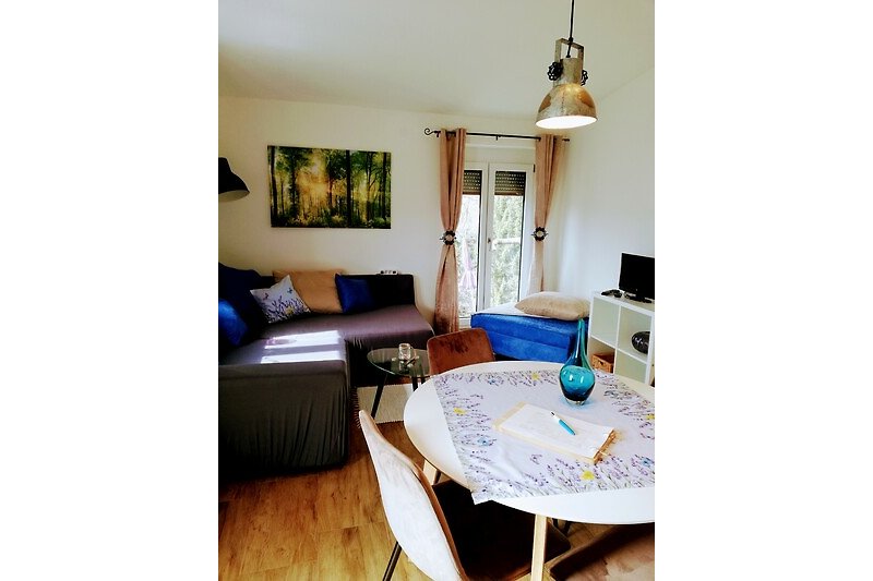 Wohnzimmer mit Holzmöbeln, Couch, Tisch und blauer Dekoration.