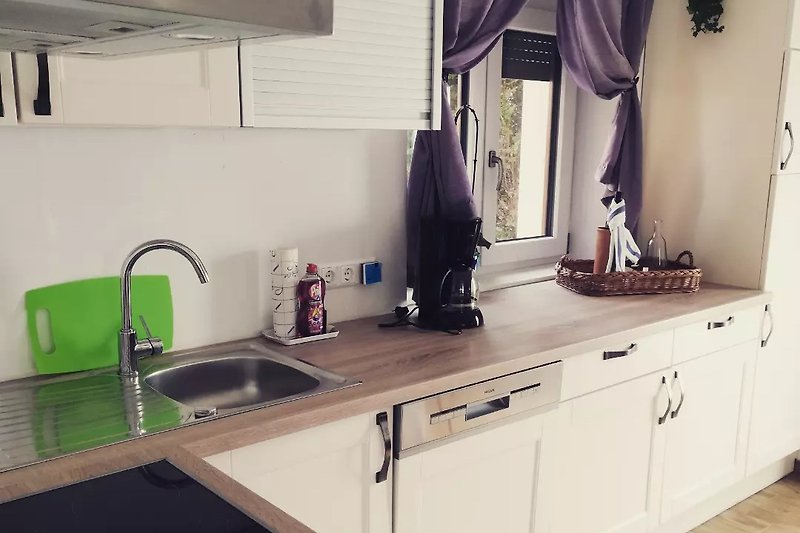 Moderne Küche mit lila Akzenten, Holzmöbeln und stilvollem Design.